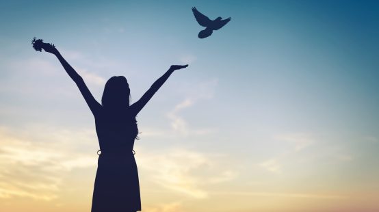 Happy woman rise hand and birds on sky background