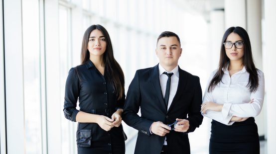 The business people walk in the office hall on the sun background