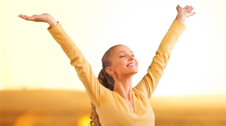 Woman feeling free in a beautiful natural setting, in what field at sunset