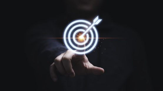 Businessman hand touching to target dart board for setup and achievement objectives target for business investment concept.