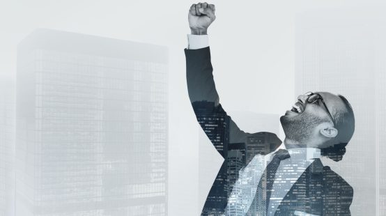 Successful businessman raising his hand in the air
