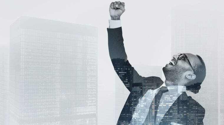 Successful businessman raising his hand in the air