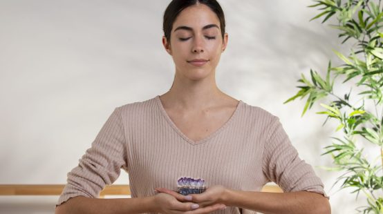 medium-shot-smiley-woman-holding-purple-crystal