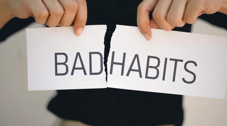 Woman Holding a torn paper hands with the words Bad Habits , Self development concept